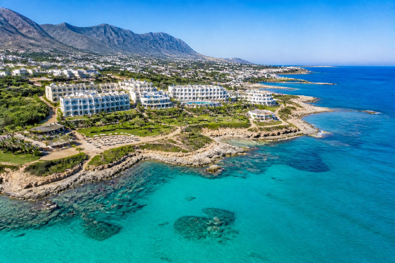 Aerial view of luxury resorts along the Kyrenia coastline with turquoise waters